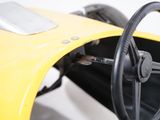 steering wheel and dashboard of a yellow race car on a white background