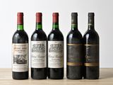 quatre bouteilles de vin sont alignées sur une table en bois