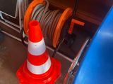 orange and white traffic cone sitting on top of a blue chair