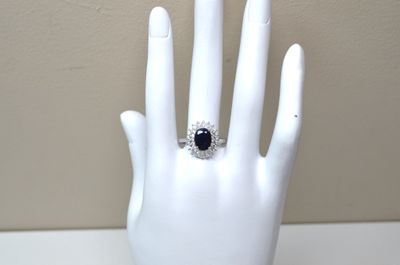 a white hand with a black and white ring on it