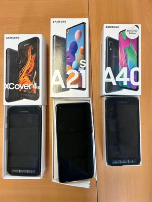 Quatre téléphones Samsung sont posés sur une table, dans une boîte