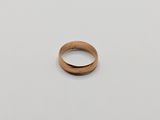 gros plan d'une bague en or sur une surface blanche