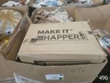 une boîte en carton sur laquelle est accrochée une pancarte indiquant « Make it Shapers »
