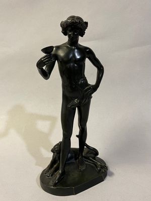 statue en bronze représentant un garçon tenant un oiseau sur un rocher