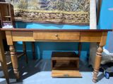 a wooden desk with a drawer underneath it in a room