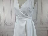 a photo of a white dress on a mannequin stand