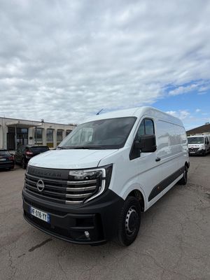 une camionnette blanche garée sur un parking, avec d'autres véhicules en arrière-plan