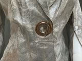 a silver jacket with a brown button on it