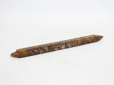 a close up of a pencil laying on top of a white surface