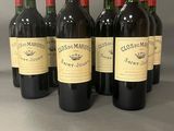 six bouteilles de vin rouge sont alignées sur une table