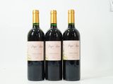 trois bouteilles de vin posées sur une table blanche