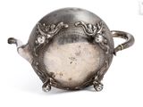 a silver teapot that is sitting on a white surface