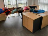 un bureau sur lequel sont posés des vêtements, dans un coin de la pièce