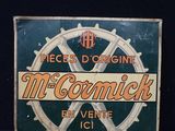 une vieille enseigne métallique faisant la promotion des cigarettes McCormick sur fond noir