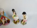 three figurines of a man and a woman sitting on top of each other