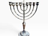a metal menorah with five candles on a white background