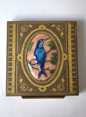 un oiseau bleu perché sur une branche d'arbre dans une boîte décorative