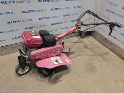 an image of a pink lawn mower parked in a garage