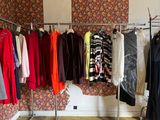 a lot of clothes hanging on a rack in a room