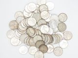 a pile of silver coins on a white surface