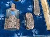 a lot of silver items that are on a blue cloth