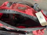 un sac rouge muni d'une étiquette, posé par terre