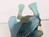 a glass figurine of a frog on a table