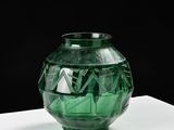 un vase en verre vert posé sur une table blanche