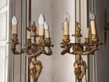 deux chandeliers dorés posés sur une table en bois dans une pièce