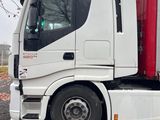 a white semi truck with a red cab parked in a parking lot