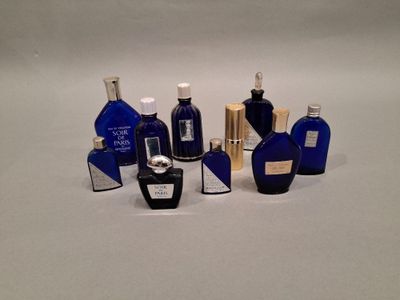 many different bottles of perfume on a white surface