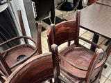 Dans un restaurant, les tables et les chaises sont alignées, prêtes à accueillir les clients.