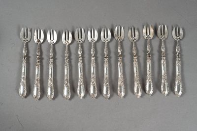 Six fourchettes et cuillères plaquées argent sont alignées sur une table