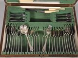 many forks and spoons in a box with a spoon in it