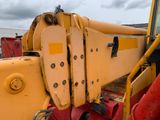 a close up of a yellow crane on the ground