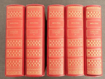 six livres rouges alignés sur une table