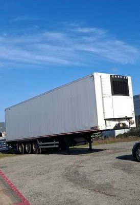 a truck that is driving down the road next to a car
