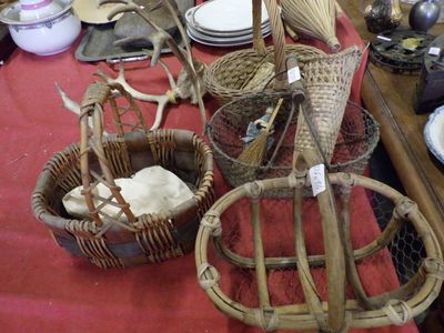 a table with baskets and plates on it with a red table cloth