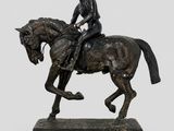 bronze statue of a man riding a horse on a marble base