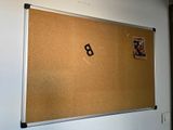 a cork board hanging on the wall in a room