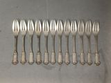 six fourchettes sont alignées en rang sur une table
