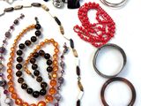 many different colored beads and bracelets laid out on a white surface
