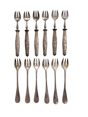 six forks and two spoons are arranged on a white surface