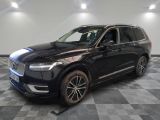 a black volvo suv parked on a checkered floor in a showroom