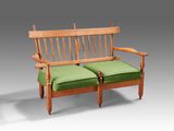 a wooden bench with two green cushions on it