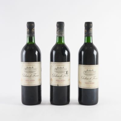 trois bouteilles de vin posées les unes à côté des autres sur une surface blanche
