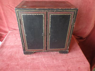 a small black cabinet with two doors on top of it