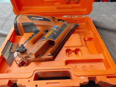 une mallette orange contenant une agrafeuse et une agrafeuse