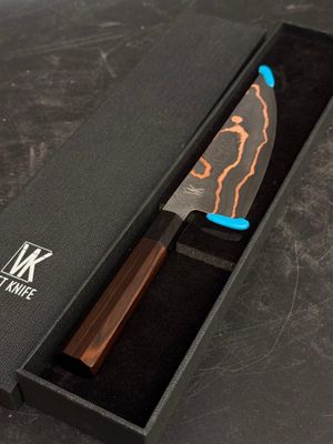 un couteau dans une boîte noire posée sur une table