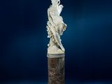 une statue ancienne représentant une femme assise sur un socle en marbre